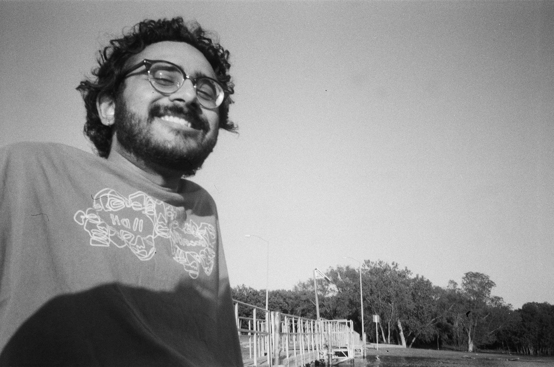 A black and white photograph of Zain smiling.